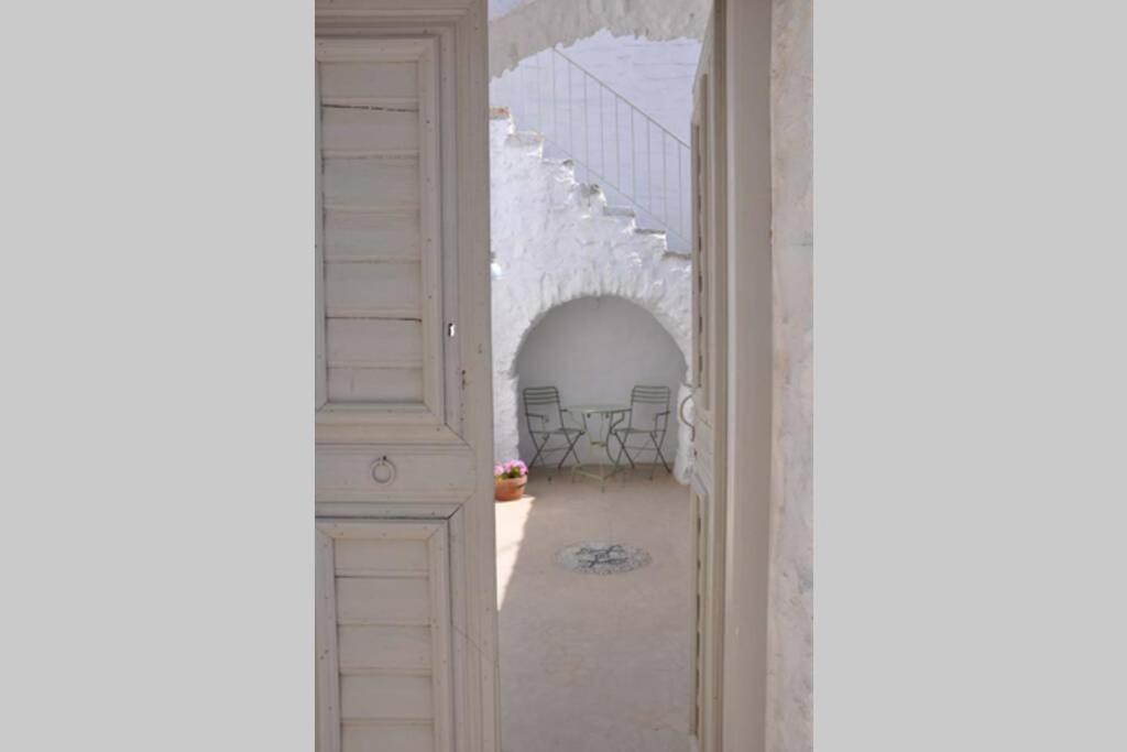 an open door to a white room with a hallway at Chora Elegant Traditional House in Amorgos