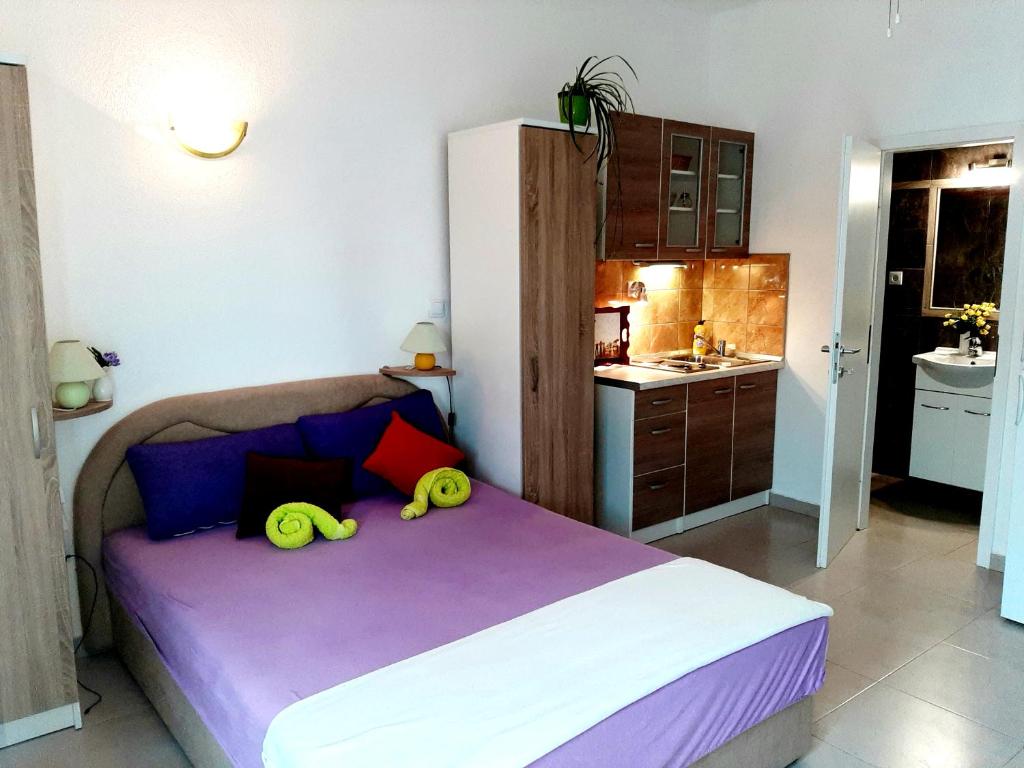 a bedroom with a bed with two yellow handles at Apartments Luxor in Rogoznica