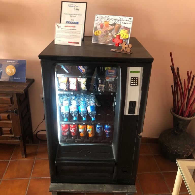 una máquina de refrescos negro con bebidas en una habitación en Hospedería Luis de Góngora, en Córdoba