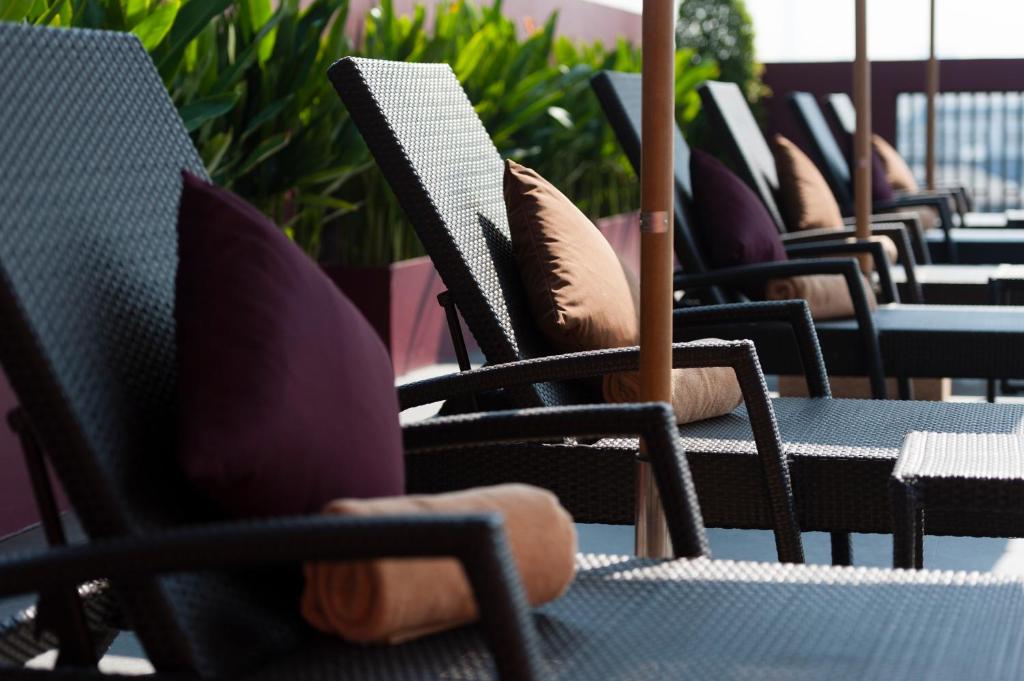 A poolside-style terrace lined with cushioned loungers and outdoor tables.
