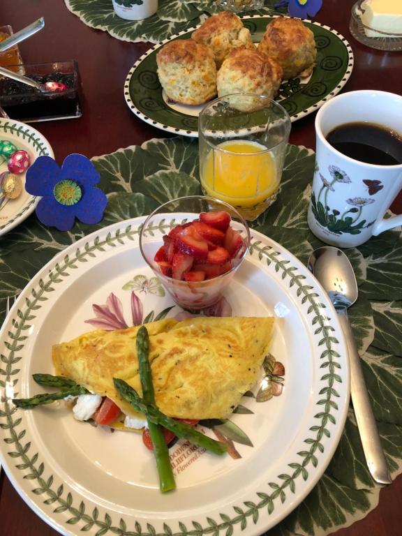 einen Tisch mit einem Teller Essen mit Omelett und Obst in der Unterkunft Bailey House Bed and Breakfast in Annapolis Royal