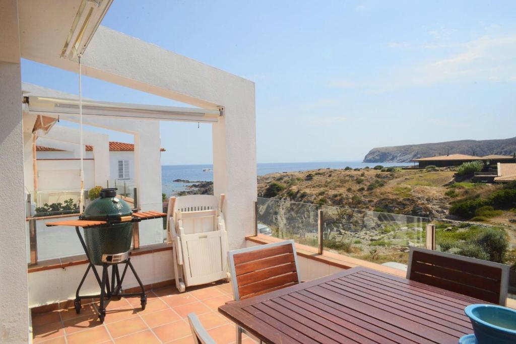 d'un balcon avec une table et une vue sur l'océan. dans l'établissement Beachfront Duplex with Terrace and Sea Views -, à Cadaqués