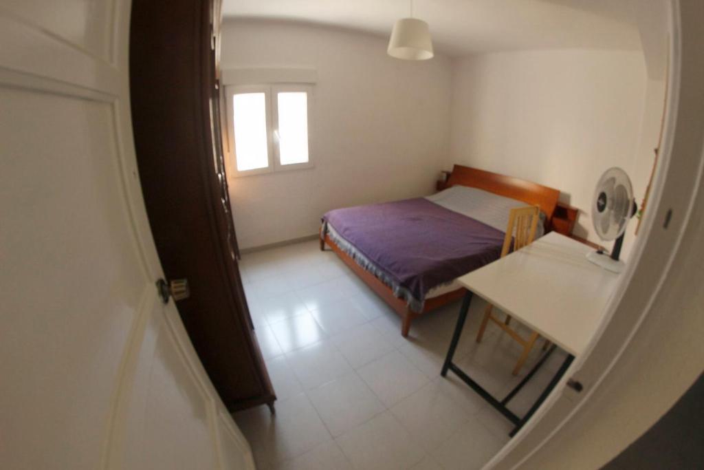 Habitación pequeña con cama y mesa en apartemento ideal familia y grupo climatisacion playa poblaA, en Valencia