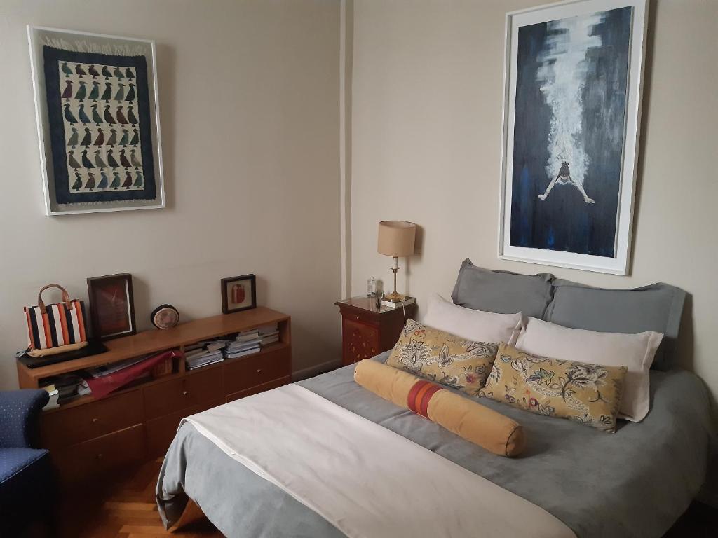 a bedroom with a bed and a painting on the wall at Corazón de Recoleta in Buenos Aires