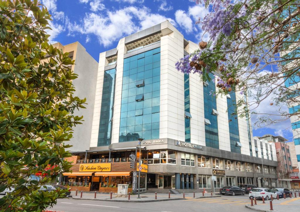 um grande edifício com janelas de vidro numa rua da cidade em Hotel Ismira em Esmirna