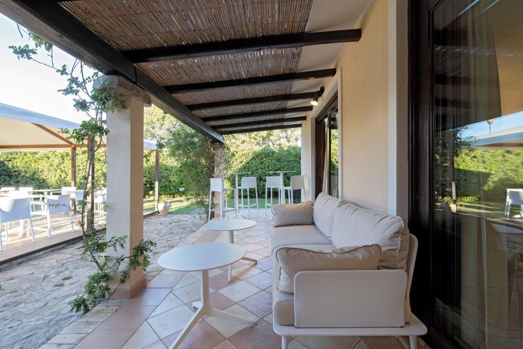 a living room with a couch and tables on a patio at Porto Giunco Residence in Villasimius