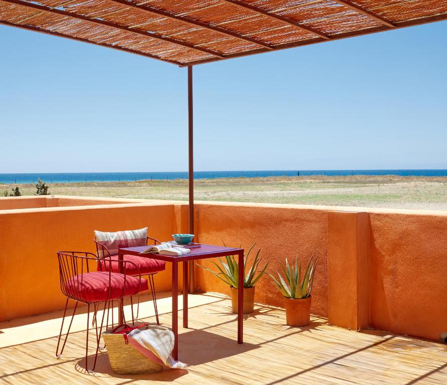 a patio with a table and two chairs and an umbrella at Trafalgar Polo Club in El Palmar