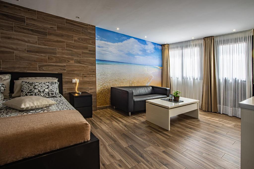 プラヤ・ハンディアにあるSuite del Mar 3 Jandiaのベッドルーム1室(ベッド1台、ソファ、テーブル付)