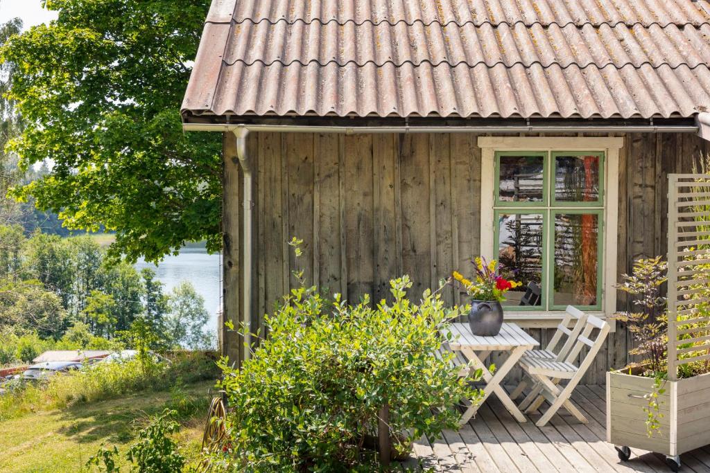 a wooden house with a table and chairs on a deck at Sustainable and soulful close to lake in Gnesta