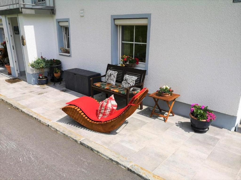 a patio with a chair and a table and a window at Ferienwohnung Gerti in Mauth