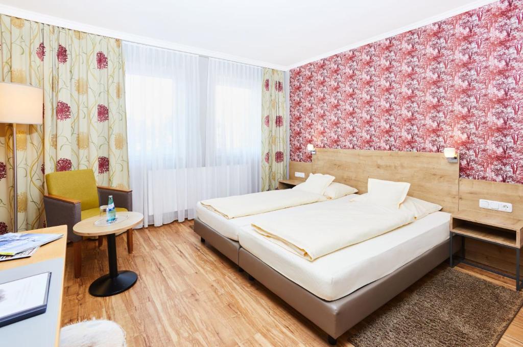 Schlafzimmer mit einem Bett und einem Schreibtisch in der Unterkunft Landhotel Kuralpe Kreuzhof in Lautertal