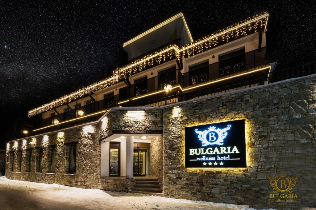 a building with a sign on it at night at Wellness Hotel Bulgaria in Bansko