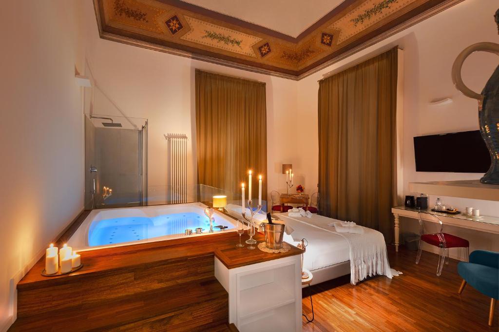 Habitación con baño con bañera azul grande. en Naca Suite, en Catania