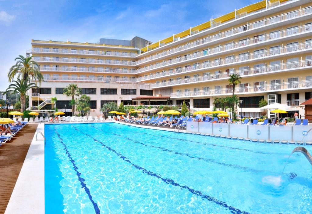 a pool in front of a hotel at GHT Oasis Park & Spa in Lloret de Mar