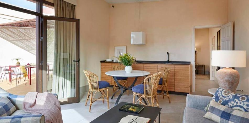a living room with a table and a kitchen at Trafalgar Polo Club in El Palmar