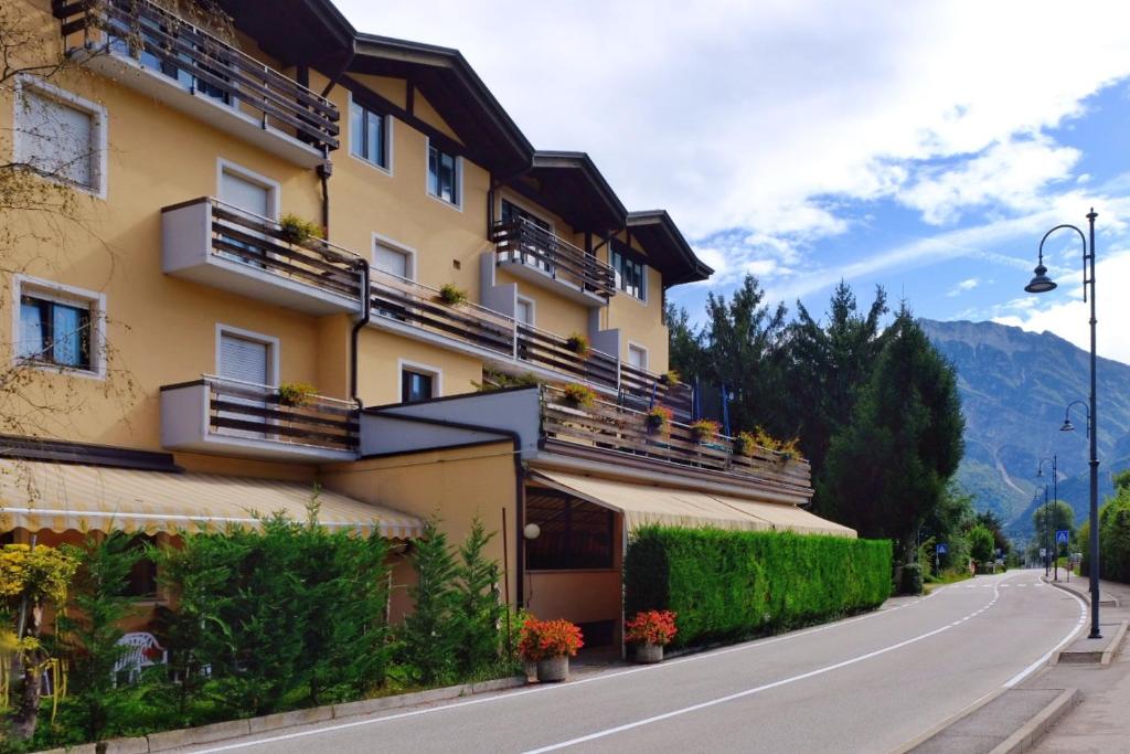 a building with balconies on the side of a road at Hotel Dolomiti in Levico Terme