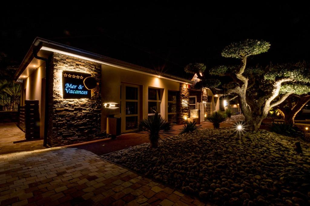 a building with a sign on it at night at M&V Resort Camping in Langrune-sur-Mer
