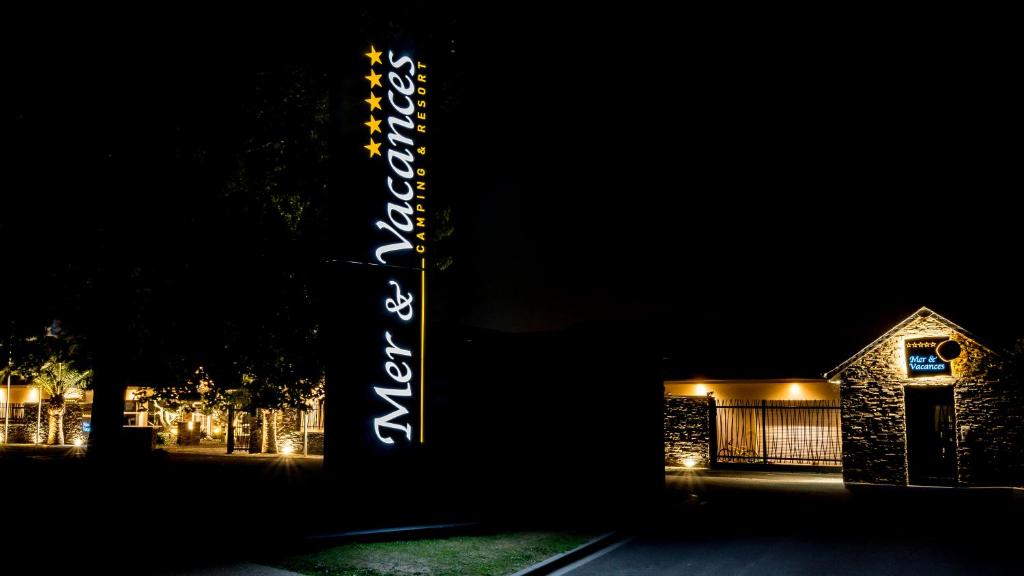 a sign that is lit up in front of a building at M&V Resort Camping in Langrune-sur-Mer