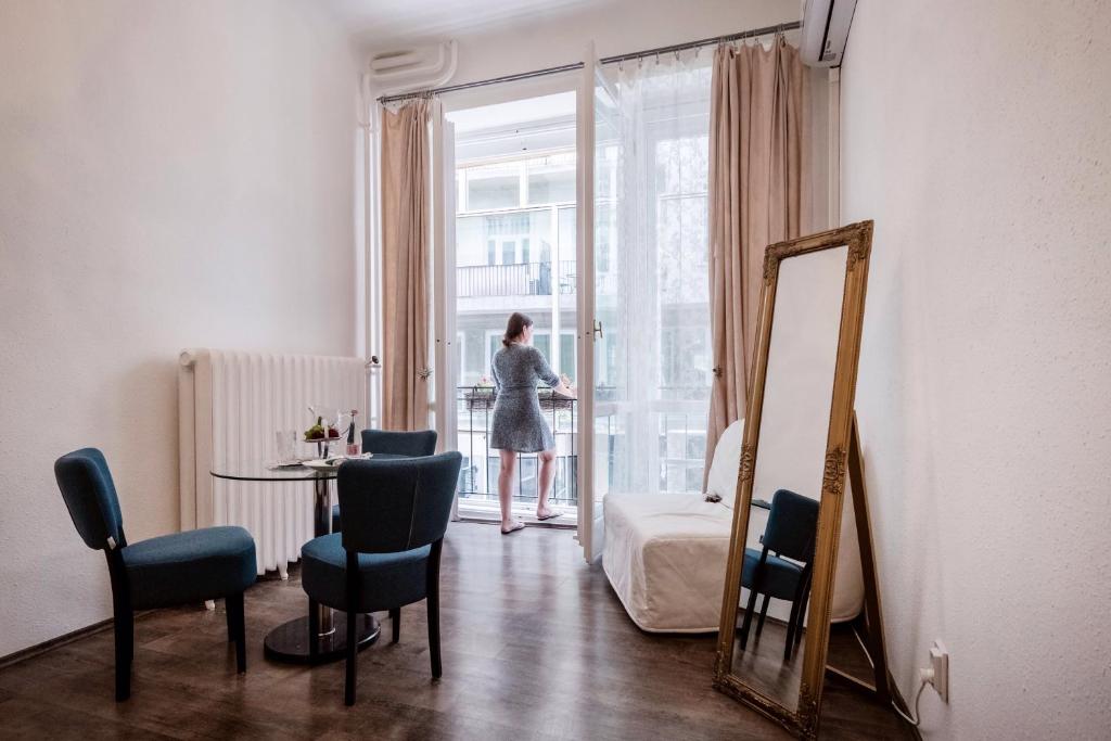 a woman standing in a room looking out the window at Hungaricum Budapest in Budapest