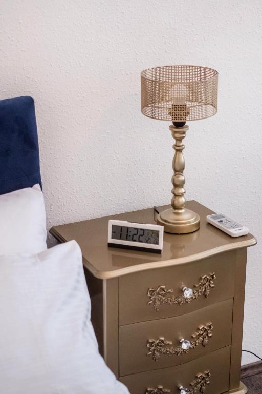 a bedside table with a lamp and a clock on it at Hungaricum Budapest in Budapest