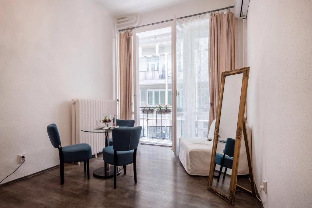 a room with a table and chairs and a mirror at Hungaricum Budapest in Budapest