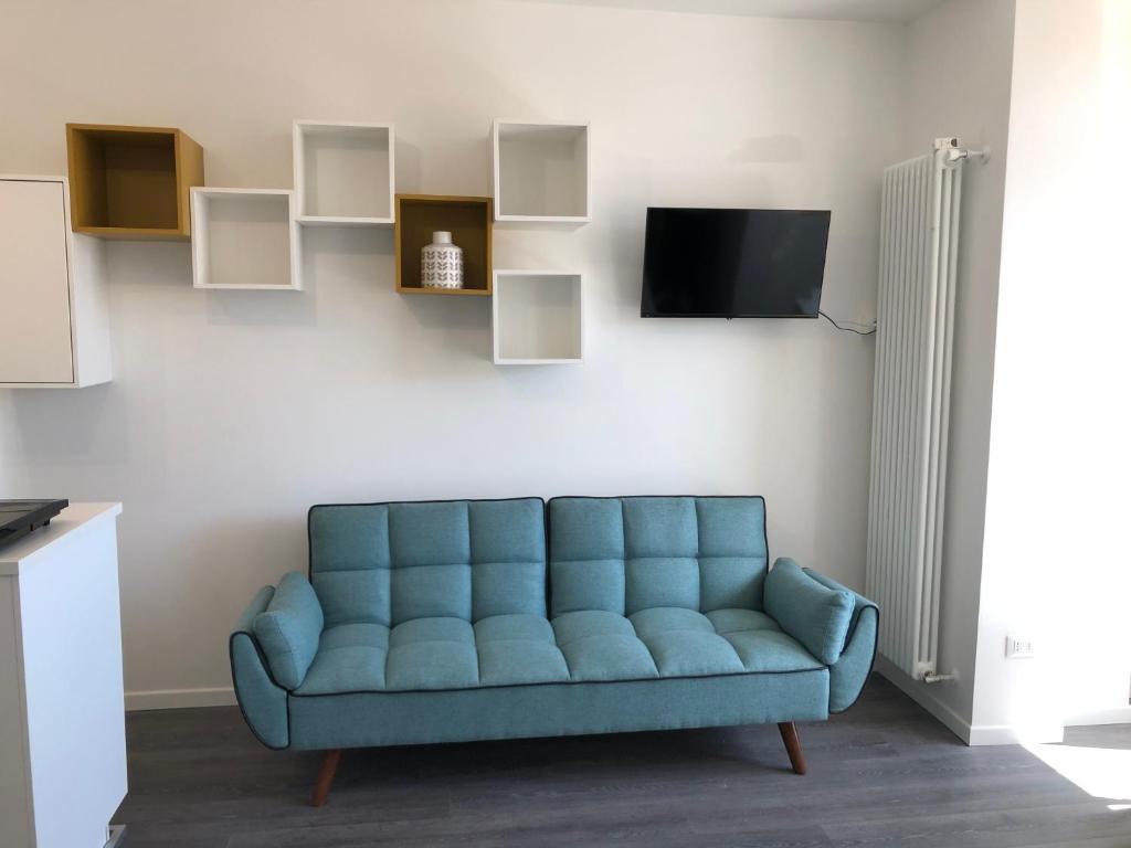 un divano blu in soggiorno con TV di Appartamenti Scrovegni a Padova