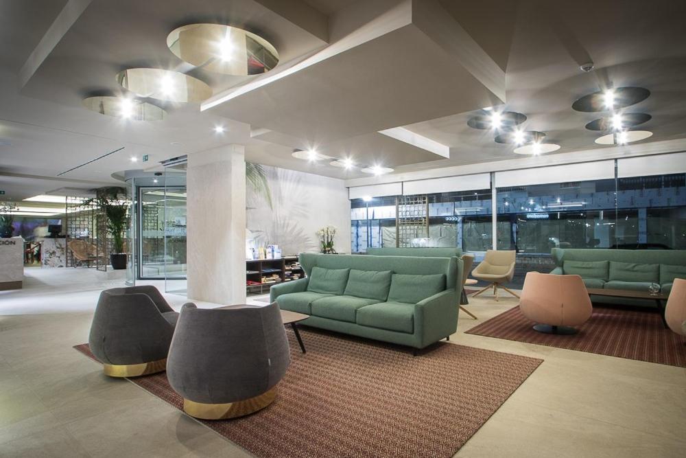 a lobby with couches and chairs in a building at Les Dunes Comodoro in Benidorm