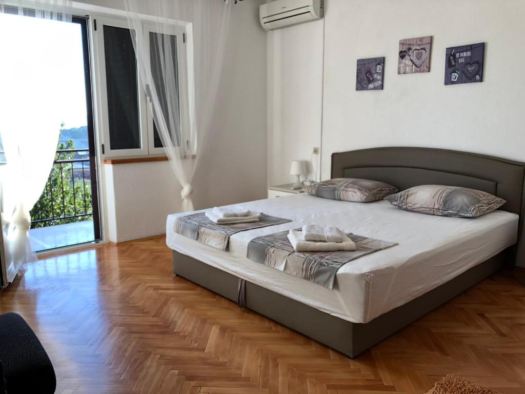ein Schlafzimmer mit einem großen Bett mit Holzboden in der Unterkunft Apartment DAZ in Makarska