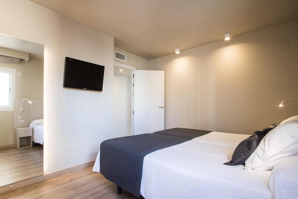 a bedroom with a bed and a tv on the wall at Les Dunes Comodoro in Benidorm