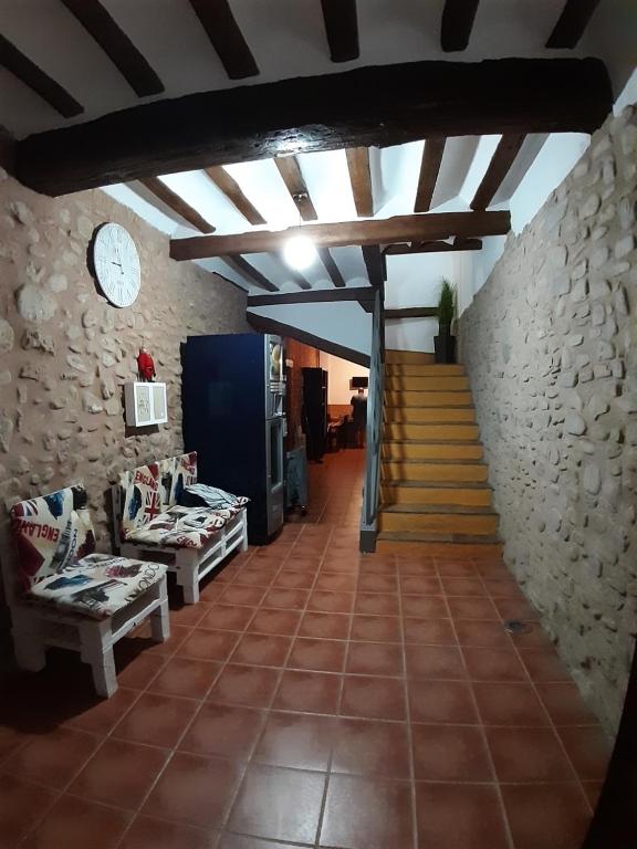 a living room with a staircase and a stone wall at Vivienda Turistica La Catedral in Santo Domingo de la Calzada