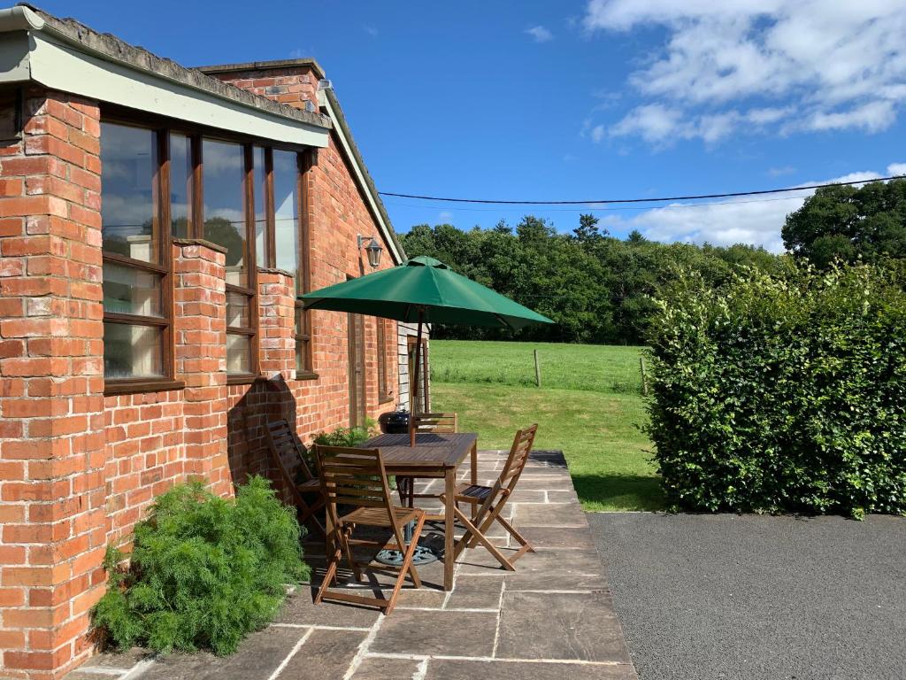 ein Tisch und Stühle mit einem Sonnenschirm auf einer Terrasse in der Unterkunft The Old Bull Pen in Abergavenny