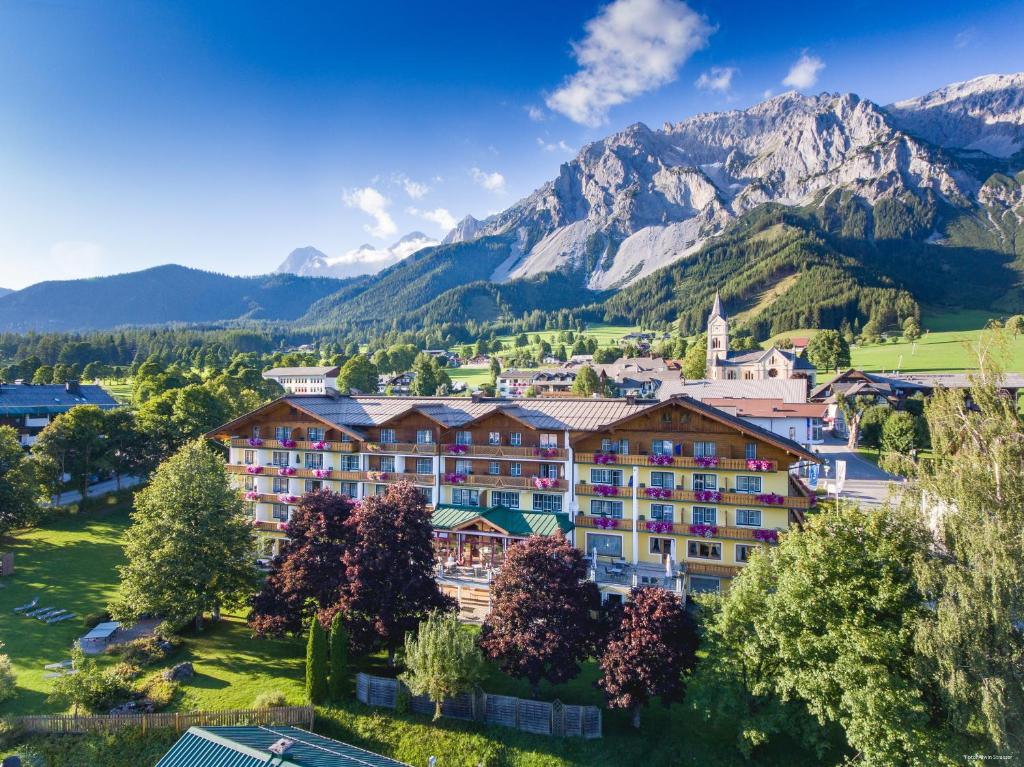 a resort in the mountains with mountains in the background at Hotel Matschner in Ramsau am Dachstein