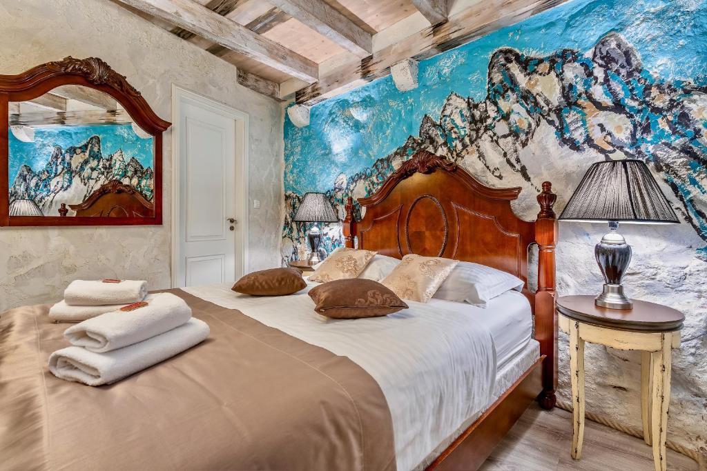 a bedroom with a large bed with a painting on the wall at Historic Plaza Varos Split in Split