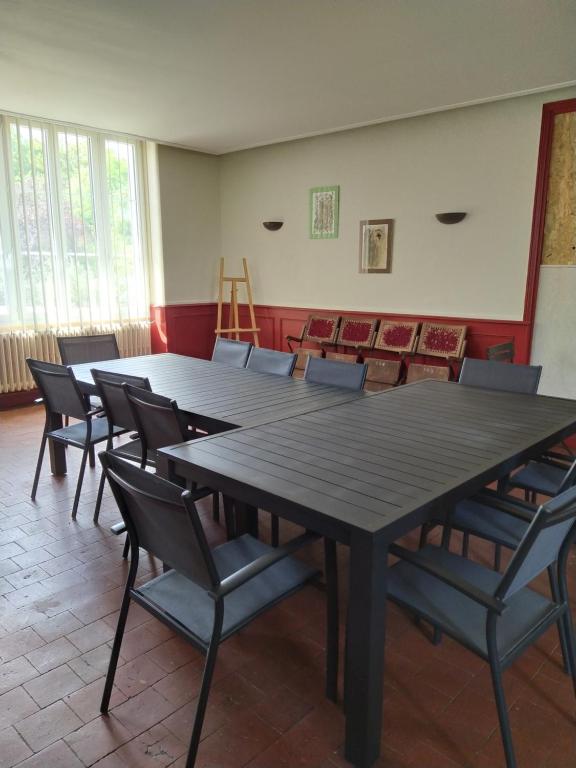 une salle de conférence avec une grande table et des chaises dans l&#39;établissement Gite de la Gare, à Varzy