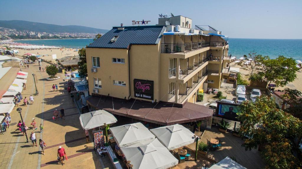 um edifício ao lado de uma praia com pessoas e guarda-sóis em Hotel Star em Sunny Beach