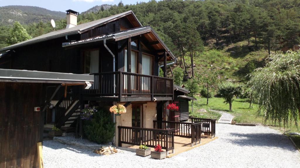 Maison noire avec balcon sur une montagne dans l'établissement Chalet Espace Lumière - Spa, sauna et salle de fitness, à Méolans