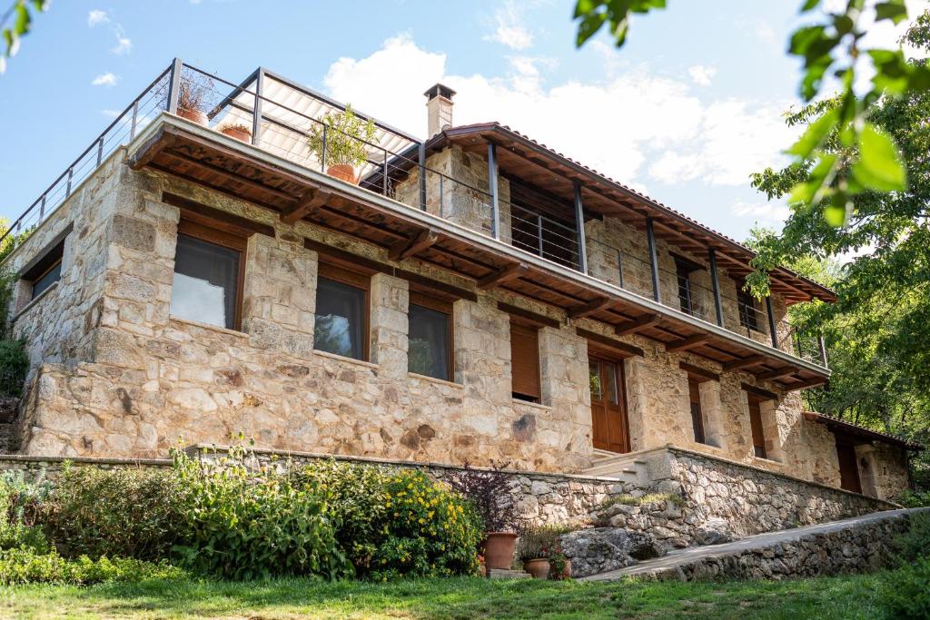 an old stone house with a man on top of it at Lujosa casa en la Ribeira Sacra in Acova