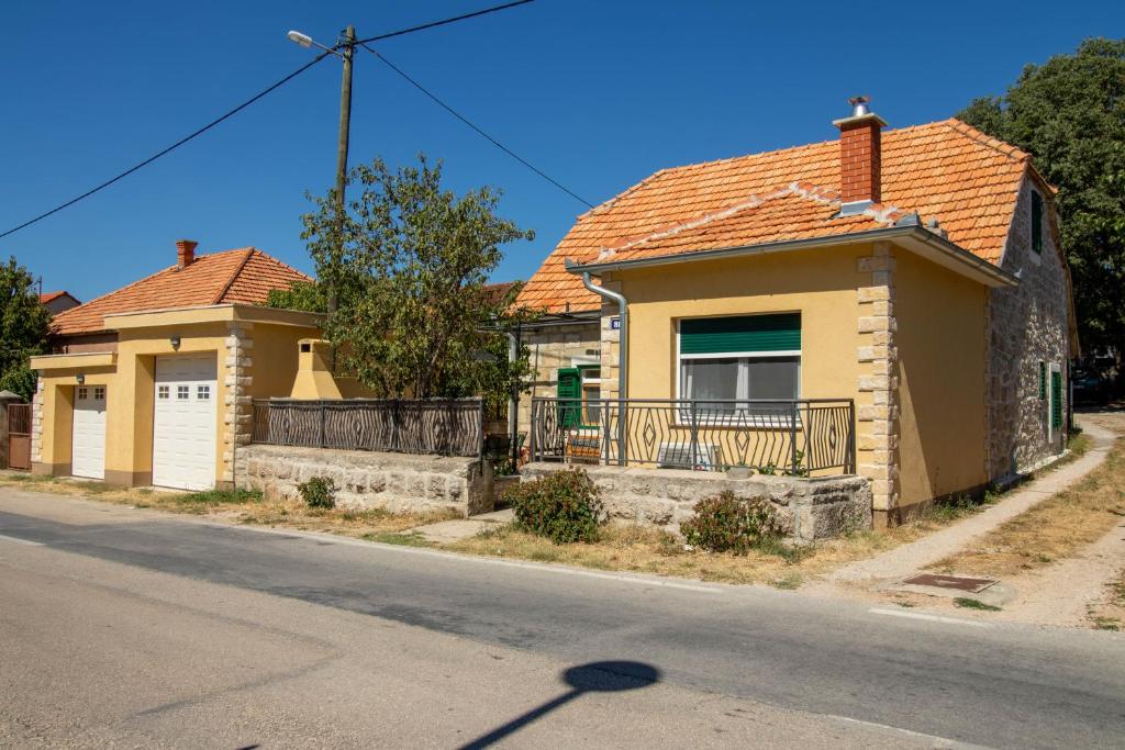 a yellow house with an orange roof at Apartman Ivan in Drniš