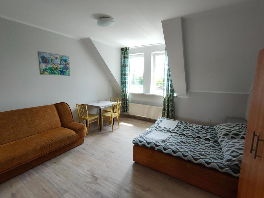 sypialnia z łóżkiem, kanapą i stołem w obiekcie Pokoje blisko morza przy promenadzie w Kołobrzegu