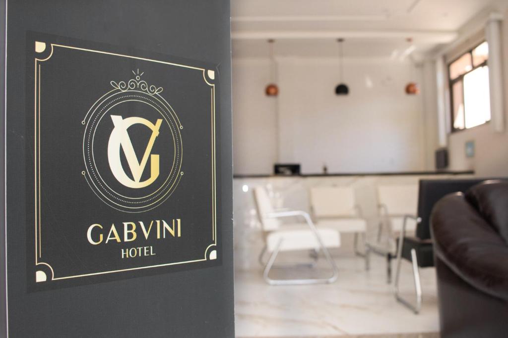 a sign for a hotel with a dining room in the background at Gabvini Hotel in Lima Duarte