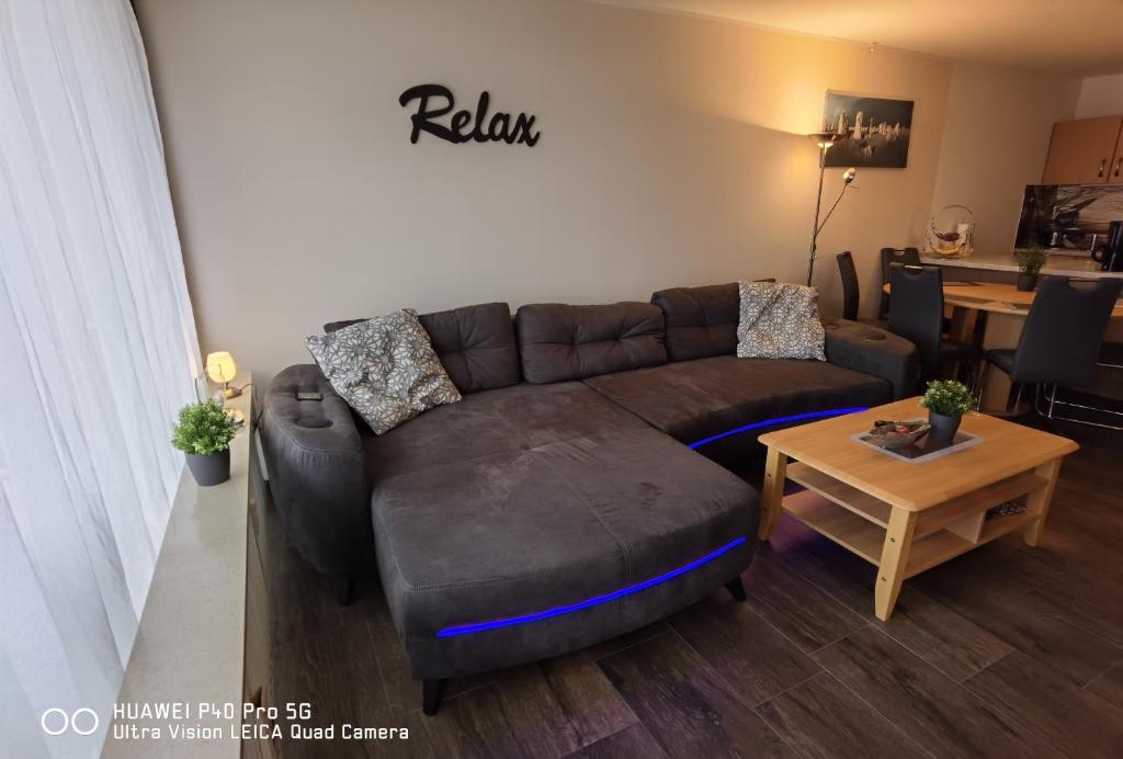 un soggiorno con un divano marrone e un tavolo di Ferienwohnung Weitblick 274 a Hohegeiss