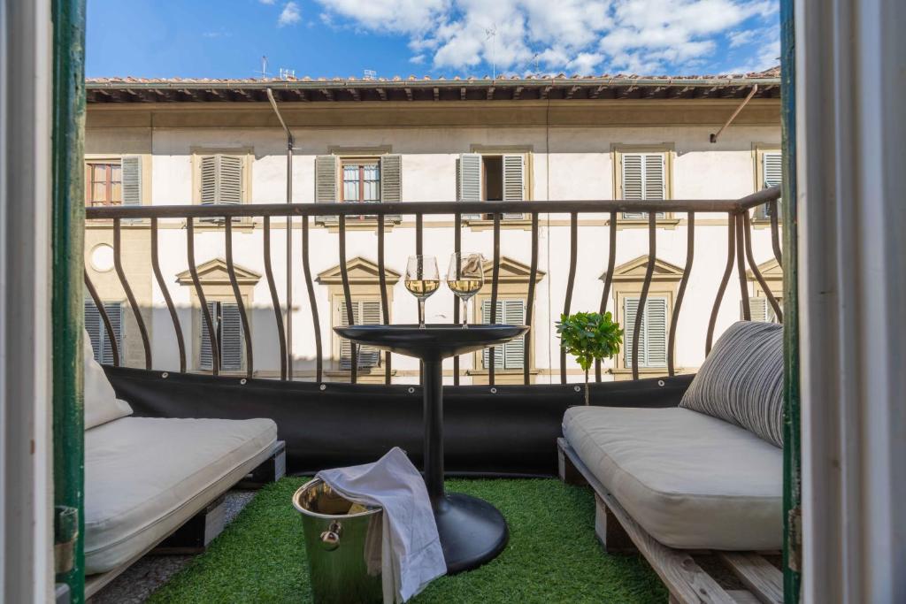 un balcón con mesa y 2 sillas y un edificio en We Florence Terrace Resort en Florencia