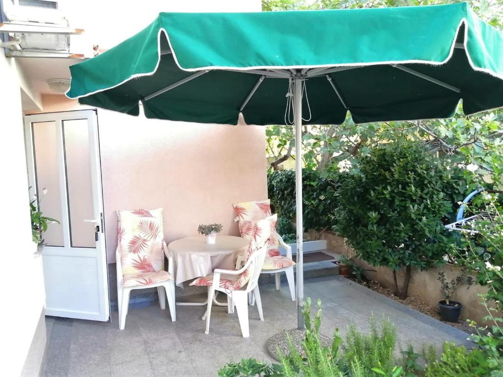- une table et des chaises sous un parasol sur la terrasse dans l'établissement Apartman Mario, à Makarska
