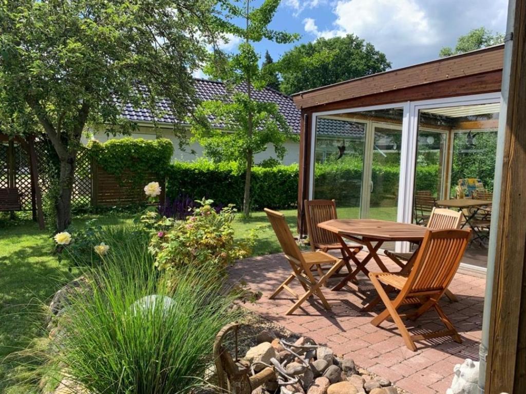 een patio met een tafel en stoelen in een tuin bij Ferienhaus in absoluter Seenähe für 4 Personen in Arendsee