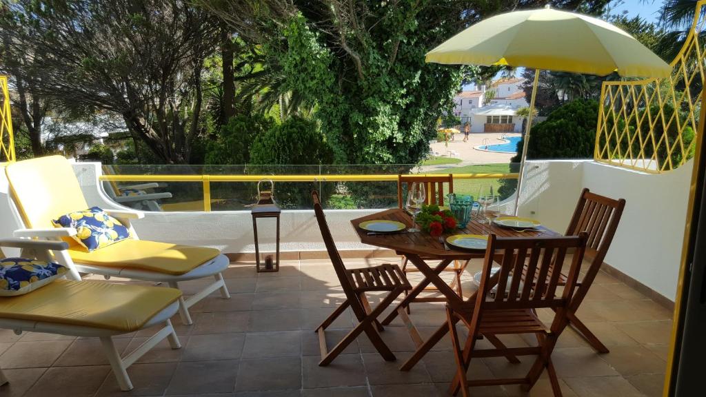 a patio with a table and chairs and an umbrella at Sunshine Apartment in Quarteira