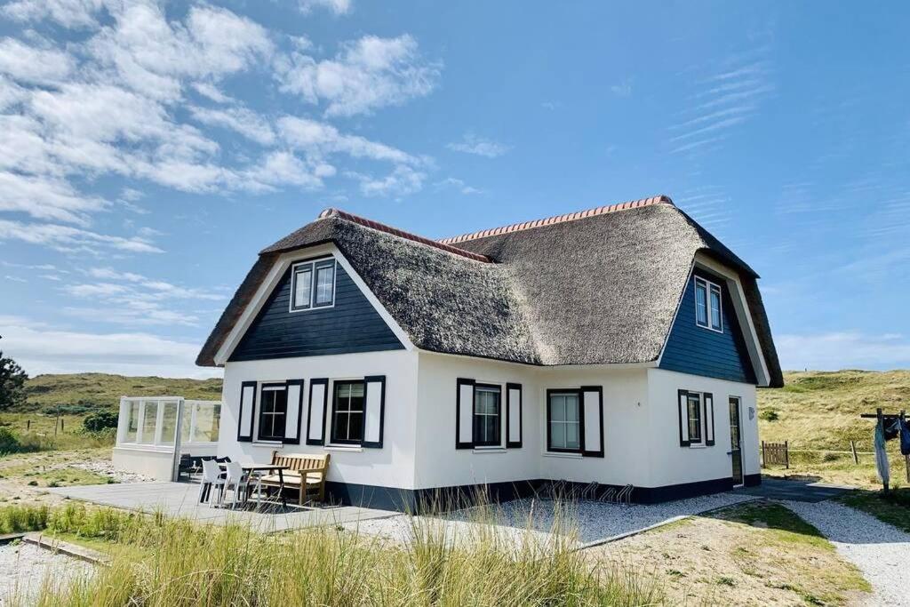 a small white house with a gray roof at Duinvilla Sela in Hollum