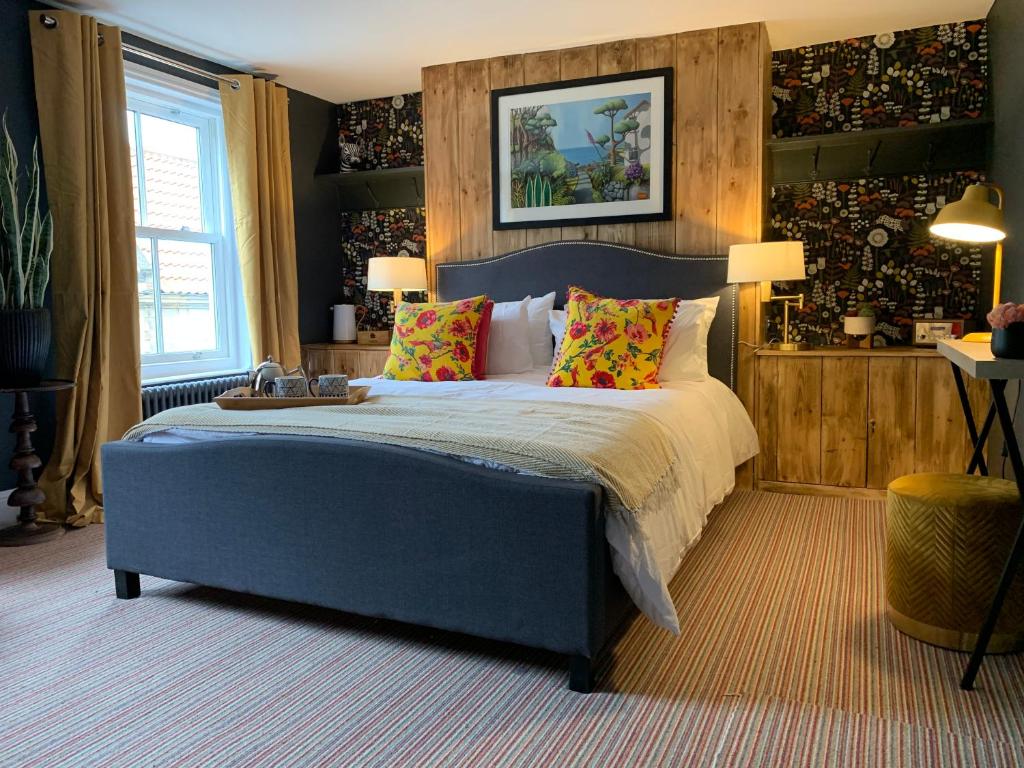 a bedroom with a large bed with colorful pillows at Sherlocks lodgings in Whitby