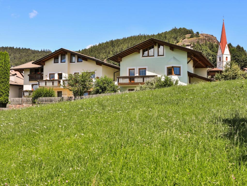 una casa en la cima de una colina con un campo verde en Apartment Sonnwies, en Verano