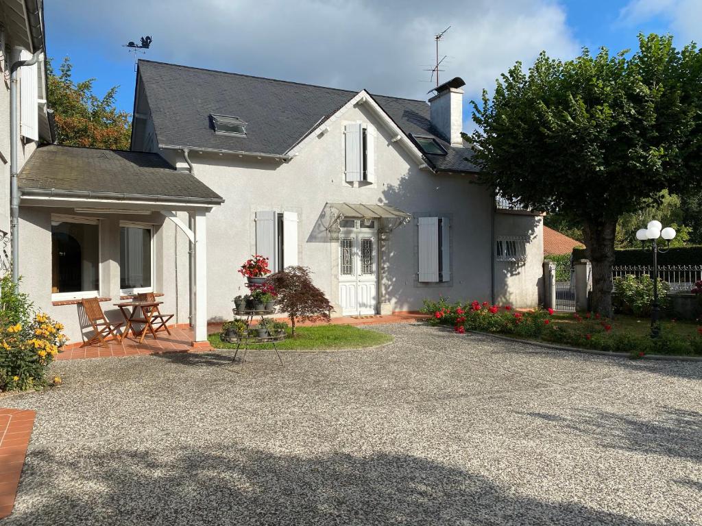 une maison blanche avec une table et des chaises dans l'allée. dans l'établissement Aou Saintou, à Morlaas