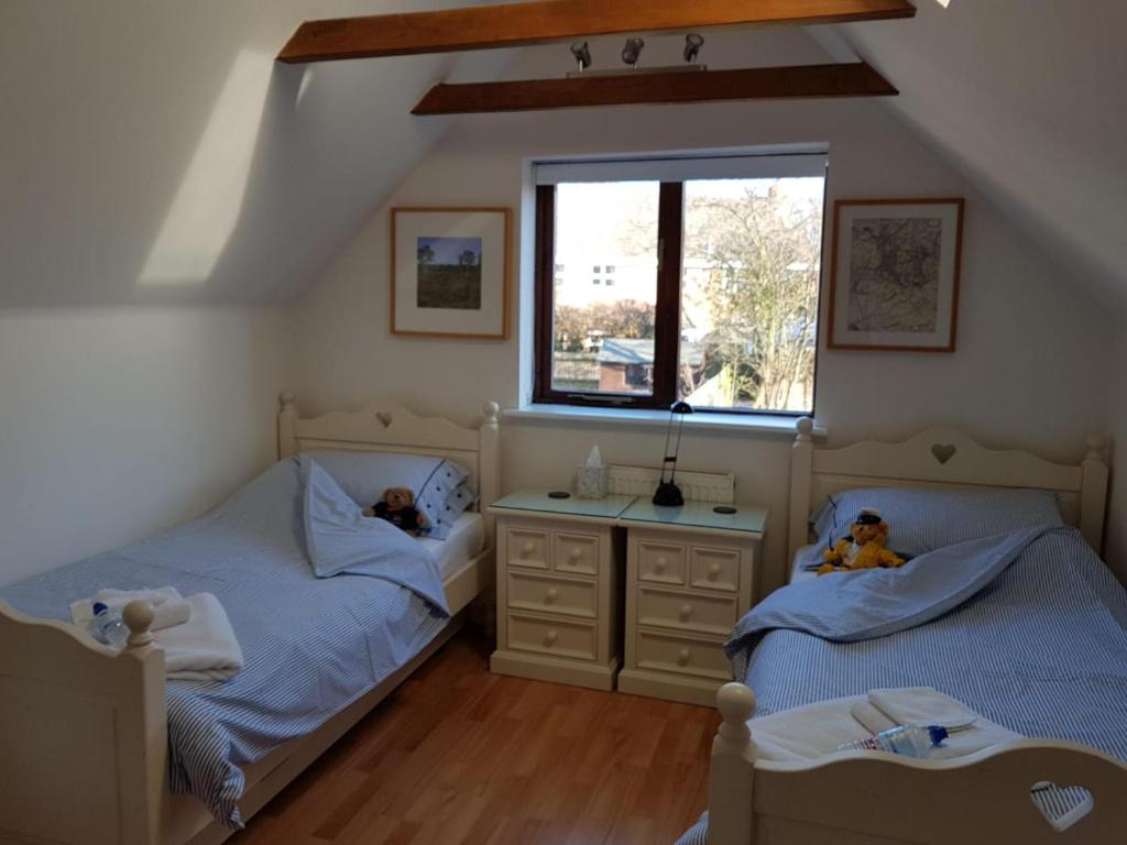 two twin beds in a room with a window at Binfield Annexe in Bracknell